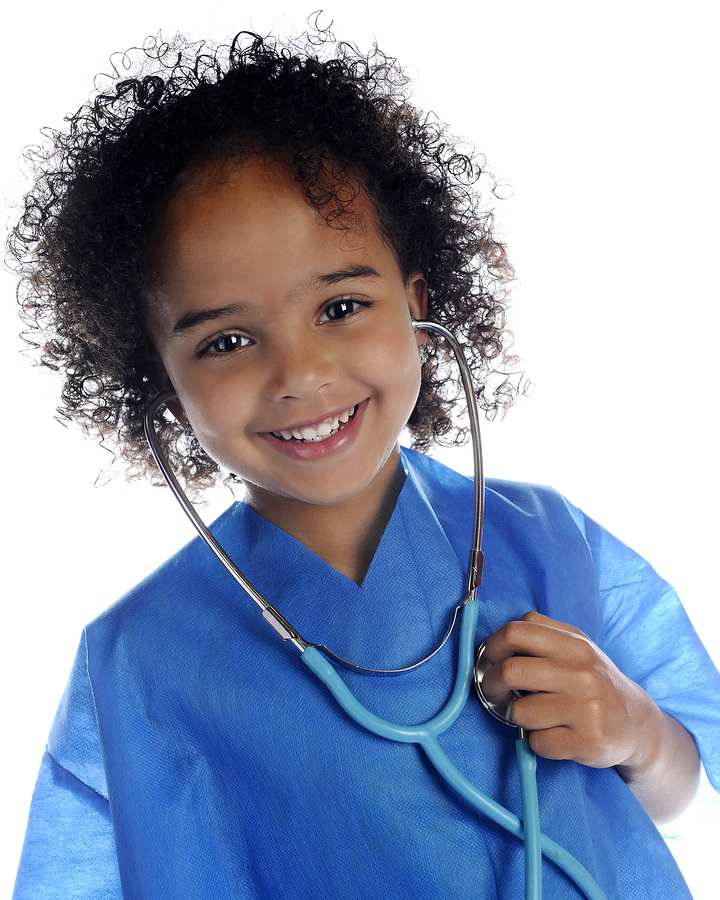 portrait of an adorable preschool "doctor" in scrubs happily lis