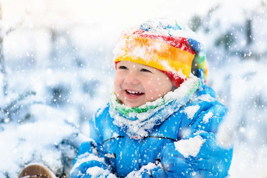 baby playing with snow in winter. child in snowy park.