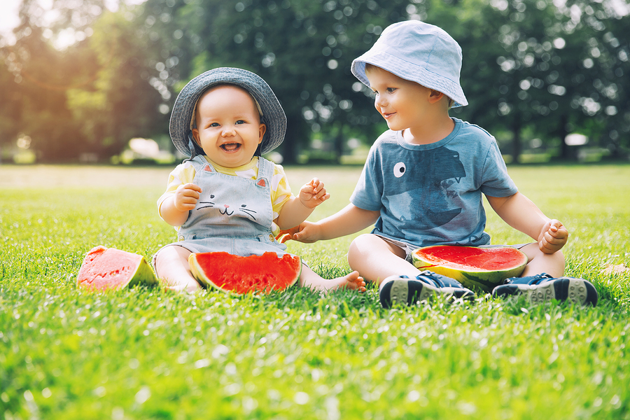 funny children eating watermelon on nature at summer